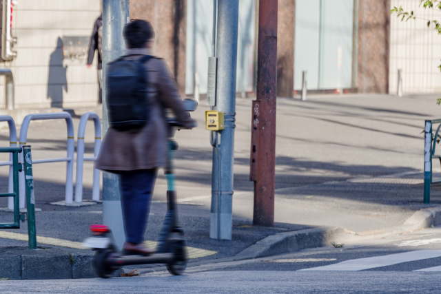 電動キックボードで公道を走行する男性